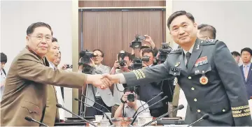  ?? — Reuters photos ?? Ahn (left) shakes hands with Kim during a meeting at the Peace House of the border village of Panmunjom, South Korea.