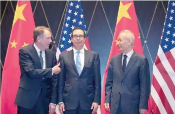  ??  ?? US Trade Representa­tive Robert Lighthizer gestures towards Treasury Secretary Steven Mnuchin as he chats with Chinese Vice Premier Liu He before they pose for a family photo at the Xijiao Conference Center in Shanghai, China. — Reuters