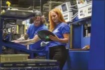  ??  ?? Press operators Chico Tamilia, left, and Ivy Lovell check a record made from vinyl pucks. The company says it can turn out 3.6 million discs in a year.