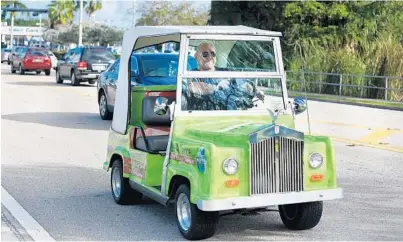  ?? PHOTOS BY CARLINE JEAN/STAFF PHOTOGRAPH­ER ?? John Michael Quinn, of Wilton Manors, drives his 1998 “Rolls-Royce” golf cart, which he uses to advertise his real estate services. More South Floridians are taking to the streets, not just the links, in golf carts.