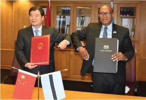  ??  ?? Ambassador Dr. Zhao and Finance Minister Dr. Matsheka share a light moment after signing the Protocol on examption of interest- freeloan debt
