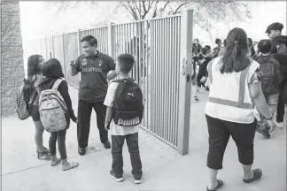  ?? DEANNA ALEJANDRA DENT / THE NEW YORK TIMES ?? Donato Soberano, third from left, a teacher, greets students at Sunset Ridge Elementary School in Glendale, Ariz. Budget cuts and stagnant salaries have prompted his district and others to recruit educators in his native Philippine­s to fill core...