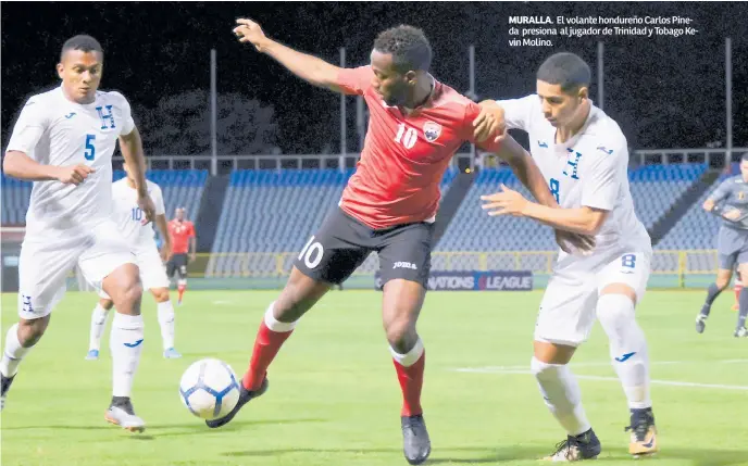  ??  ?? MURALLA. El volante hondureño Carlos Pineda presiona al jugador de Trinidad y Tobago Kevin Molino.