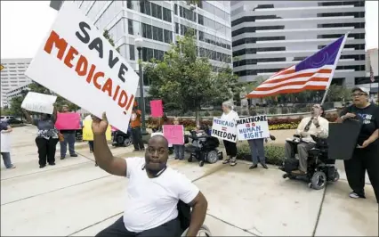  ??  ?? Mario Henderson leads chants of "Save Medicaid" as other activists and Medicaid recipients protest outside the offices of U.S. Sen. Thad Cochran, R-Miss., on June 29 in Jackson, Miss.