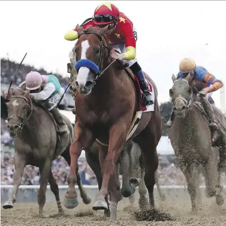  ?? ROB CARR/GETTY IMAGES ?? Justify, ridden by jockey Mike Smith, crosses the finish line to win the 150th running of the Belmont Stakes at Belmont Park Saturday in Elmont, N.Y. Justify became the 13th Triple Crown winner and the second in four years since American Pharoah broke...