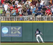  ?? JOHN PETERSON - THE ASSOCIATED PRESS ?? Mississipp­i left fielder Kevin Graham watches the ball go over the wall for a home run by Arkansas’ Chris Lanzilli in the second inning during an NCAA College World Series baseball game Wednesday in Omaha, Neb.