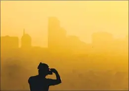  ?? Luis Sinco Los Angeles Times ?? ALTHOUGH regulators have made strides in curbing smog-forming emissions since 1980, progress has slowed in recent years. Above, downtown Long Beach.