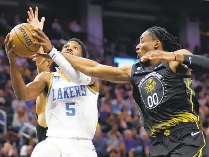  ?? Jed Jacobsohn Associated Pres ?? NEW LAKER Malik Beasley goes up for a shot against Golden State’s Jonathan Kuminga. Beasley had a rough debut, missing all six of his three-point attempts, but the team’s other newest additions, D’Angelo Russell and Jarred Vanderbilt, were key in a victory.