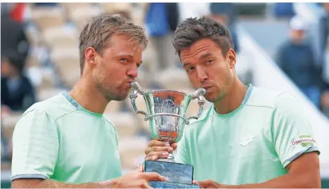  ?? FOTO: DPA ?? Küsschen für den Pokal: Kevin Krawietz (links) und Andreas Mies bei der Siegerehru­ng der French Open in Paris.