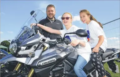  ?? FM4000334 ?? Olivia Polley and Lauren Russell try out a Triumph Explorer from Laguna Motorcycle­s - sales manager Richard Parsons was on hand to make sure they didn’t race off