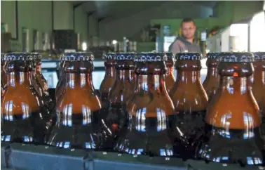  ?? AP PHOTO BY NEIL SHAW ?? Bottles of freshly bottled beer stand in the Darling Brewery in Darling, South Africa. The South African brewery appears to be the first in Africa to go carbon-neutral.