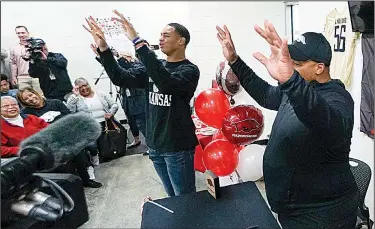  ?? Arkansas Democrat-Gazette/MITCHELL PE MASILUN ?? Joe T. Robinson defensive end Zach Williams (left) calls the Hogs alongside his father, former Arkansas linebacker Rickey Williams, after signing a letter of intent to play football at Arkansas on Wednesday, the first day of the NCAA early signing period.