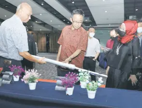  ?? Ministry ?? A member of the Mud Skipper team shows Abdul Karim and permanent secretary Nancy Jolhi how their invention works.