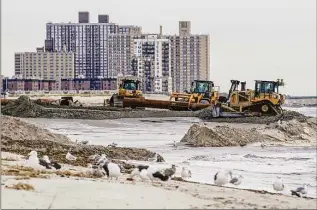  ?? Julia Nikhinson / Associated Press ?? Workers construct a pipe for sand dredging on Oct. 18 in the Far Rockaway neighborho­od of the Queens borough of New York. The U.S. Army Corps of Engineers’ Atlantic Shorefront Resiliency Project aims to construct a reinforced dune system designed to block storm surge.