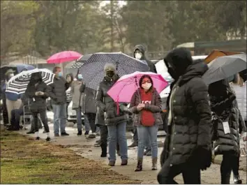  ?? Genaro Molina Los Angeles Times ?? PEOPLE wait in a standby line at Balboa Sports Center in Encino on Friday, hoping to receive a COVID-19 vaccine if extra shots are available. Deaths related to the disease are expected to rise in the days ahead.