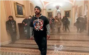  ?? AP ?? Smoke fills the walkway outside the Senate chamber on Thursday as proTrump rioters confront police.