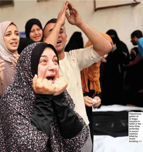  ?? AFP ?? Palestinia­ns gather at Al Najjar Hospital in Rafah in the Gaza Strip yesterday to mourn relatives killed by Israeli bombing