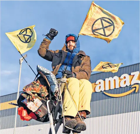  ?? ?? An activist in Avonmouth. Extinction Rebellion said it was protesting against consumeris­m on Black Friday, ‘environmen­tally destructiv­e business practices’ and working conditions