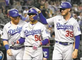  ?? Rick Scuteri Associated Press ?? THE DODGERS’ Mookie Betts, middle, is congratula­ted by Justin Turner, left, and Cody Bellinger after Betts hit a three-run home run in the ninth inning.