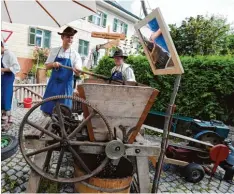  ?? Foto: Marcus Merk ?? Dominik Heinle und Günter Klaus (von links) pressen Apfelsaft mit einer 100 Jahre al ten Maschine.