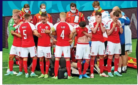  ??  ?? PROTECTIVE: Denmark players form a ring round the star as he is treated, above, and console his partner Sabrina Kvist Jensen, right