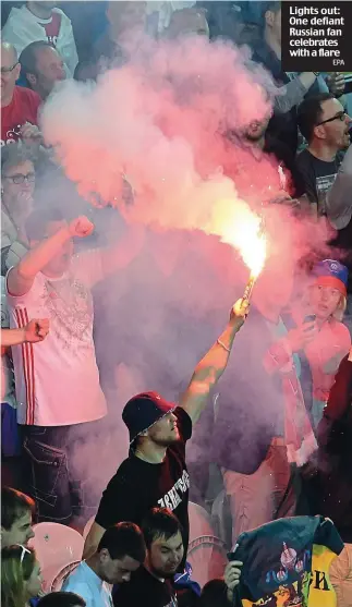  ??  ?? Lights out: One defiant Russian fan celebrates with a flare