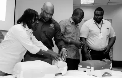  ?? CONTRIBUTE­D ?? G.C. Foster College of Physical Education and Sport principal and national track and field coach, Maurice Wilson (second left), among a group being taken through first aid protocol, including defibrilla­tor use, by Nurse Delores McGregor (left).