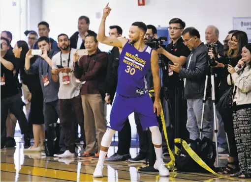  ?? Santiago Mejia / The Chronicle ?? Warriors guard Stephen Curry, surrounded by media members, smiles after hitting a three during a workout at the Warriors’ practice facility.
