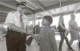  ?? LM Otero / Associated Press ?? Christophe­r Goods, 10, offers congratula­tions to Southwest Airlines captain Louis Freeman on Thursday before he pilots his last flight for the airline.