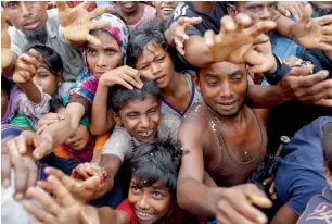  ?? AFP ?? Rohingya refugees wait for aid at Kutupalong refugee camp in the Bangladesh­i town of Teknaf. —