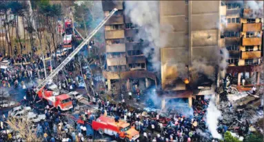  ?? MAJID/ GETTY IMAGES ?? The scene of devastatio­n is pictured after an Iranian military plane crashed into a residentia­l building in a heavily built-up suburb of Tehran yesterday. All 94 people aboard the plane were killed, as well as at least 34 people on the ground.