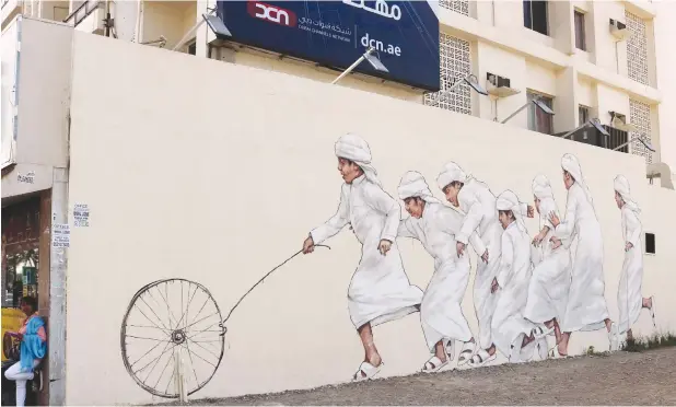  ?? Pictures: AFP ?? WALL ART. Graffiti by Malaysian-based Lithuanian artist Ernest Zacharevic on a wall of Dubai’s 2nd of December Street, which is part of the government-funded Dubai Street Museum project. Street artists are turning the walls of a fast-growing urban...