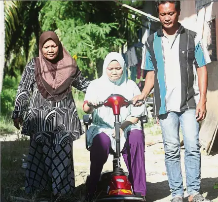  ??  ?? Siti Nuraisyah with her pillars of support – mother Maimunah and stepfather Roslan. — IBRAHIM MOHTAR/The Star