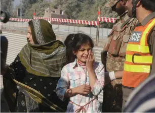  ?? AP ?? Family members of people trapped inside the agricultur­e institute wait outside during the operation against militants. —