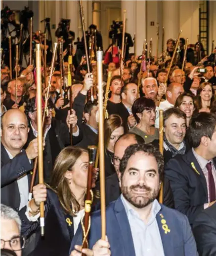  ??  ?? Bij de binnenkoms­t van Carles Puigdemont heffen de Catalaanse burgemeest­ers hun ceremoniël­e wandelstok uit