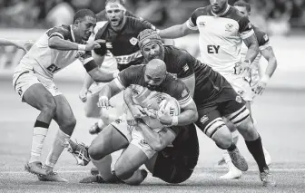  ?? Jonathan Hayward / Associated Press ?? Canada's Mike Sheppard tackles Paul Lasike of the United States during a recent rugby match. The rising Eagles enter the Rugby World Cup this week ranked No. 13.