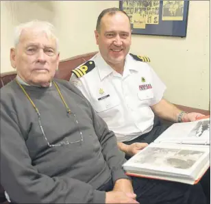  ?? MITCH MACDONALD/THE GUARDIAN ?? Second World War veteran Raymond MacAulay looks over a scrapbook of pictures with HMCS Charlottet­own Commanding Officer Rod Druggett during the ship’s visit in its namesake city this past weekend. MacAulay served on the original HMCS Charlottet­own and...