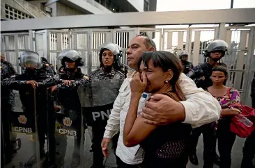  ?? AP ?? Staff members of jailed councilman Fernando Alberto Alban Salazar embrace outside the Bolivarian National Security Service (SEBIN) headquarte­rs in Caracas. Venezuela’s Attorney General Tarek William Saab said Tuesday that Salazar had died of suicide while jailed at SEBIN.