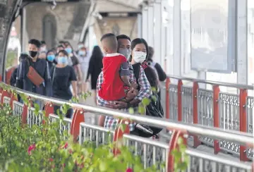  ?? NUTTHAWAT WICHEANBUT ?? People wear face masks while crossing a footbridge at Victory Monument in Phaya Thai district. A webinar by World Bank Thailand on Thursday addresses Covid-19’s impact on Thailand’s labour market.