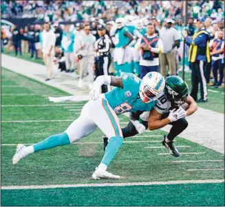  ?? N.J. (AP) ?? New York Jets wide receiver Braxton Berrios (10) takes a hit from Miami Dolphins safety Jevon Holland (8) as he dives across the goal line to score a touchdown during the fourth quarter of an NFL football game in East Rutherford,