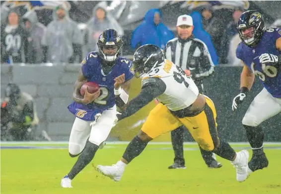  ?? KARL MERTON FERRON/STAFF ?? Ravens quarterbac­k Tyler Huntley scrambles past Steelers defensive tackle Larry Ogunjobi for 7 yards in the second quarter Saturday.
STEELERS 17, RAVENS 10