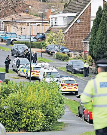  ??  ?? Police officers in the village of Crawley Down, West Sussex, where the bodies of two women were found early yesterday morning