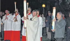  ??  ?? Pfarrer Karl Enderle und Peter Reichert tragen die Osterkerze­n von Westerheim und Ennabeuren bei einer Prozession in die Christköni­gskirche.