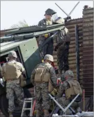  ?? JOHN GIBBINS/ THE SAN DIEGO UNION-TRIBUNE VIA AP ?? Marine Corps engineers from Camp Pendleton put up razor wire Tuesday, just east of the San Ysidro Port of Entry where trains pass from the U.S. in to Mexico and Mexico to the U.S. to support Border Patrol.