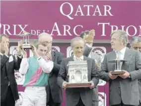  ??  ?? In this file photograph taken on October 3, 2010, jockey Ryan-lee Moore (second left) holds the trophy next to Workforce owner Khalid Abdullah (centre) and trainer Michael Stoute (second right) after winning the 89th edition of the Qatar Prix de L’arc de Triomphe horse race on Workforce at the Longchamp racecourse in Paris.