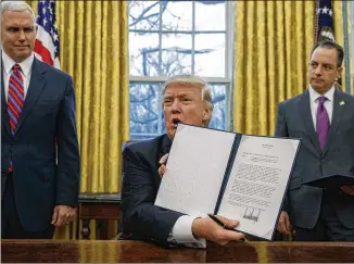  ?? EVAN VUCCI / ASSOCIATED PRESS ?? President Donald Trump (center), with Vice President Mike Pence (left) and chief of staff Reince Priebus, holds an order withdrawin­g the U.S. from the 12-nation Trans-Pacific Partnershi­p trade pact on Jan. 23. The administra­tion Thursday told Congress...