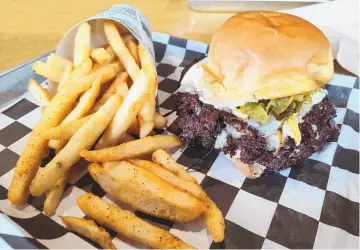  ?? RICHARD S. DARGAN/FOR THE JOURNAL ?? Top billing on Stackers’ menu goes to the Duke City burger, two patties with American cheese and green chile, served here with fries.