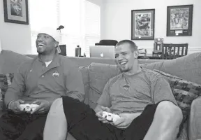  ?? COURTNEY HERGESHEIM­ER/COLUMBUS DISPATCH ?? Ohio State linebacker­s Marcus Freeman, left, and James Laurinaiti­s play video games at Laurinaiti­s' apartment in 2009.