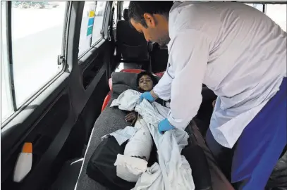  ?? Rahmat Gul ?? The Associated Press An injured boy is cared for by a medic in an ambulance Monday on the Ghazni highway, in Maidan Shar, west of Kabul, Afghanista­n. Afghan forces battled the Taliban in Ghazni, a key provincial capital, for the fourth straight day.