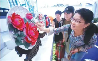  ?? CHEN XIAOGEN / FOR CHINA DAILY ?? Visitors examine porcelain products made in Luoyang, Henan province, during an internatio­nal fair for trade in services held in